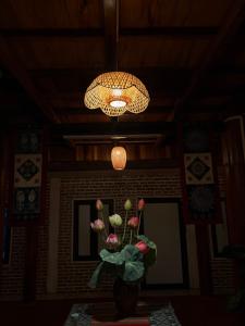 a vase of flowers in a room with a chandelier at NorthWest Home in Mai Châu