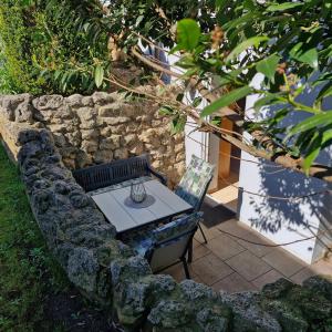 a table and a chair next to a stone wall at Ferienwohnung Kemmerth in Ebermannstadt +13 photos