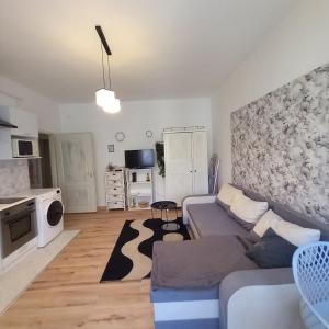 a living room with a couch and a kitchen at Lucia apartman in Kaposvár