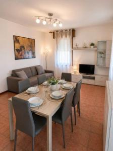 a living room with a table with chairs and a couch at APPARTAMENTI LA CONCHIGLIA in Caorle