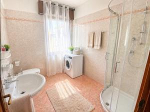 a bathroom with a shower and a sink and a washing machine at APPARTAMENTI LA CONCHIGLIA in Caorle +15 photos