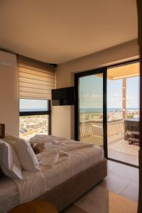a bedroom with a large bed and a large window at Dea Rethymno in Rethymno
