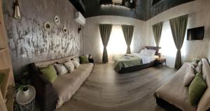 a living room with a couch and a bed in it at Casa Rahova - centru civic in Brăila