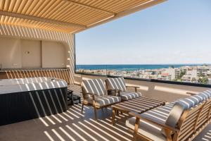 a balcony with chairs and a view of the ocean at Dea Rethymno in Rethymno