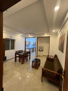 a living room with a couch and a table at Orbis Rooms & Apartments in Kakkanad