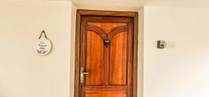 a wooden door in a hallway with a clock at The Blessing Villa Vellore in Vellore +14 photos