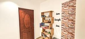 a hallway with a wooden door and a brick wall at The Blessing Villa Vellore in Vellore