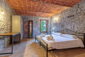 a bedroom with a bed in a stone wall at Cascina Liebe con Idromassaggio in Ozzano Monferrato +36 photos