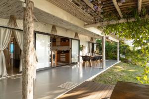 an outdoor patio with a table and chairs at Pipa Sunset Home in Pipa