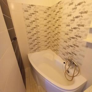 a bathroom with a white toilet in a room at Lucia apartman in Kaposvár