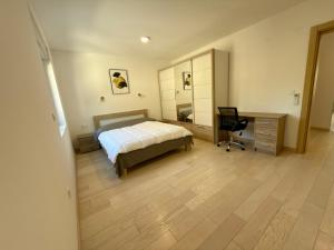 a bedroom with a bed and a desk and a chair at Lira Bay in Igalo +21 photos