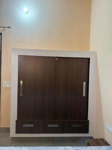 a large entertainment center with wooden doors on a wall at The Loft Homestay Narwana in Narwāna