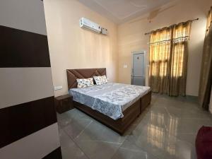 a bedroom with a bed and a window at The Loft Homestay Narwana in Narwāna
