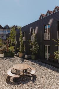 a patio with a table and benches in front of a building at Man Met Bril Koffie Hotel in Rotterdam