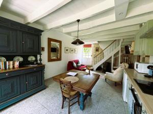 a kitchen with a table and a living room at Maison Chinsa in Saint-Angeau