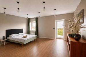 a bedroom with a bed and a wooden floor at Grava Cottage in Tukums