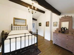 a bedroom with a bed and a dresser and a mirror at Maison Chinsa in Saint-Angeau