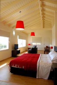 1 dormitorio con 1 cama grande y 2 lámparas rojas en La Fleur en Villa General Belgrano