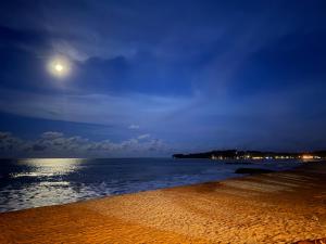a beach at night with the moon in the sky at Arugam Bay Resort in Arugam Bay