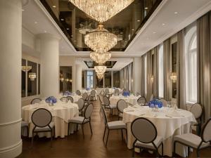 a banquet hall with white tables and chairs and chandeliers at Waldorf Astoria Helsinki in Helsinki