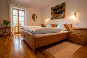 a bedroom with a large wooden bed in a room at Gästehaus Heiß in Lenggries +1 photo