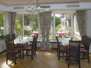 jadalnia ze stołem, krzesłami i oknami w obiekcie Hotel Störmann w mieście Schmallenberg
