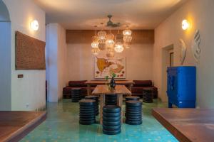 a room with a table and chairs and chandeliers at Querida Casa - Mérida Centro in Mérida