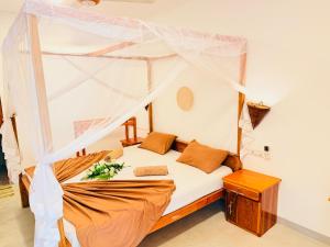 a bedroom with a bed with a canopy at Arugam Bay Resort in Arugam Bay