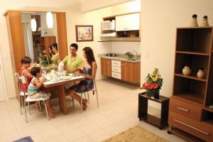 une famille assise à une table dans une cuisine dans l'établissement Serra Park - Rio Quente Reservas, à Rio Quente