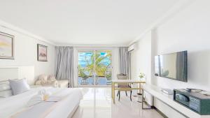 a white hotel room with a bed and a tv at Ocean Star Hotel in Koror