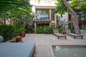 a patio with benches and a pool in front of a house at Querida Casa - Mérida Centro in Mérida +160 photos