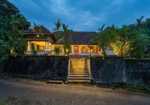 a house with a stone wall and stairs in front at Villa Mariam in Cheruvalli