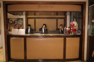 a group of three women sitting at a counter at The Ashoka Hotel in Howrah