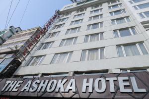 a hotel sign in front of a tall building at The Ashoka Hotel in Howrah