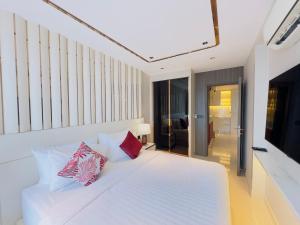 a bedroom with a white bed with colorful pillows at P Residence Phnom Penh in Phnom Penh