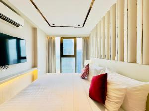 a bedroom with a white bed with red pillows at P Residence Phnom Penh in Phnom Penh