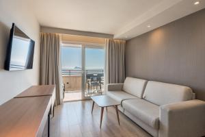 a living room with a couch and a view of the ocean at Les Dunes Comodoro in Benidorm