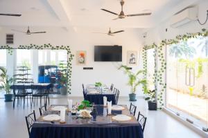 a dining room with tables and chairs and a flat screen tv at Trinco Diyash Beach Hotel in Trincomalee