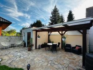 a patio with a table and chairs on a stone patio at Ferienwohnung Am Waldesrand - Garten, Terrasse, Grill, Luftkühler, Massagesessel, Kinderspielecke, Spielekonsole in Cottbus