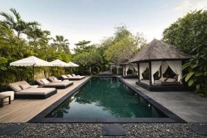 a swimming pool with lounge chairs and a gazebo at Indiana Kenanga Boutique Hotel & Spa in Nusa Lembongan