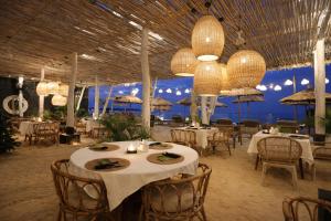 a restaurant with tables and chairs with the ocean in the background at Indiana Kenanga Boutique Hotel & Spa in Nusa Lembongan