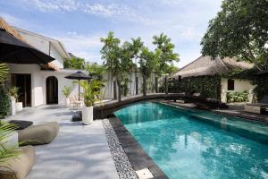 a bridge over a swimming pool next to a house at Indiana Kenanga Boutique Hotel & Spa in Nusa Lembongan