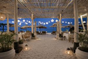 a restaurant on the beach with tables and umbrellas at Indiana Kenanga Boutique Hotel & Spa in Nusa Lembongan +61 photos