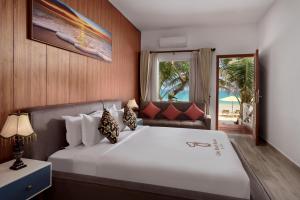 a bedroom with a large bed with a view of the beach at One Beach Resort by EHM in Koh Rong Sanloem +82 photos