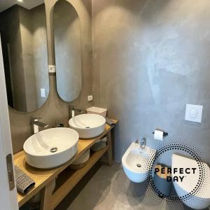 a bathroom with two sinks and a mirror at Perfect Day Luxury Residences in Palasë