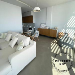 a living room with a white couch and a table at Perfect Day Luxury Residences in Palasë