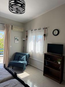 a bedroom with a bed and a tv and a window at Bougainvillea Terrace Studio in Sikéa
