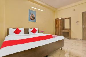 a bedroom with a large bed with red pillows at Hotel O Raas Near Hira Sweet in New Delhi