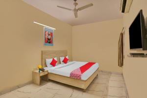 a bedroom with a bed and a flat screen tv at Hotel O Raas Near Hira Sweet in New Delhi