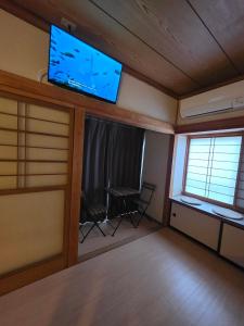 a living room with a flat screen tv on the wall at GateFuji Fujisan Station in Fujiyoshida